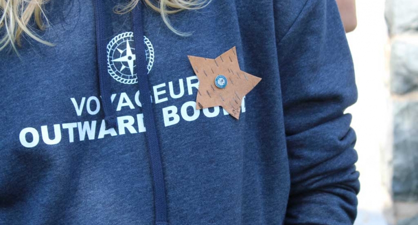 A sweatshirt reading "Voyageur Outward Bound." A star is pinned to the shirt.